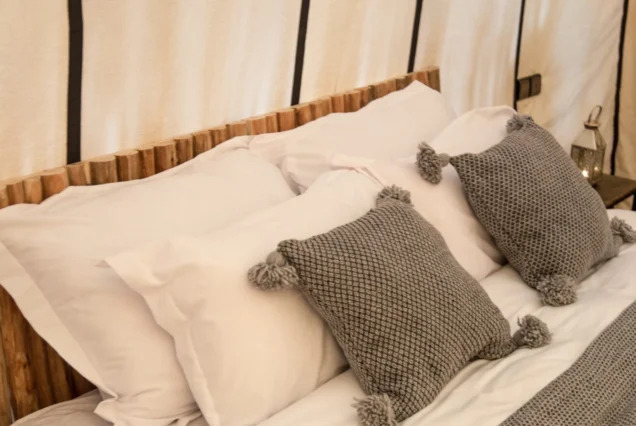 Luxury desert tent bed at Zagora Luxury Desert Camp Morocco with comfortable bedding and traditional decor